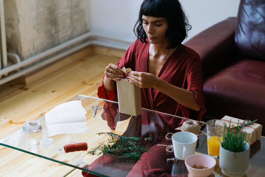 Woman wrapping Christmas gifts indoor