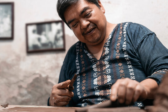 Mexican artisan sculpting with mud