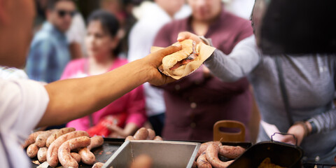 Cook selling sandwich to customer at street food stall