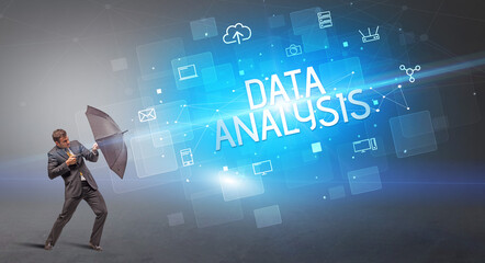 Businessman defending with umbrella from cyber attack and DATA ANALYSIS inscription, online security concept