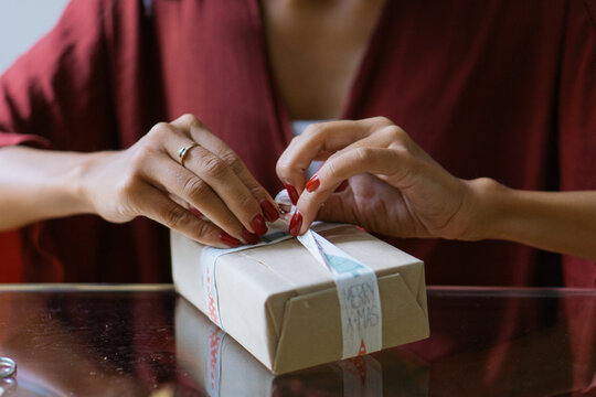 Woman wrapping Christmas gifts indoor