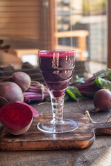Red beet juice in a glass, with fresh beetroots