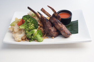 Lamb chops with vegetables in white background
