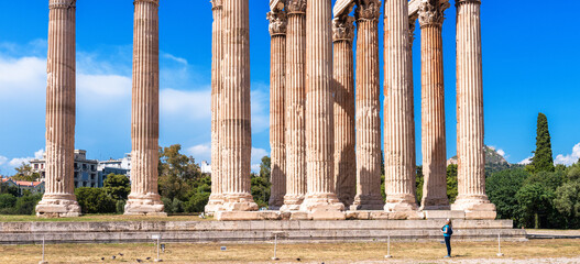 Zeus temple in summer, Athens, Greece. Tourist look at majestic Ancient Greek ruins.
