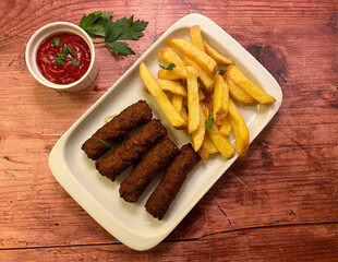 Cevapcici with french fries and ketchup. Grilled minced meat dish, a type of kebab.