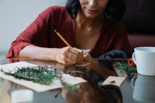 Brunette woman writing a Christmas card