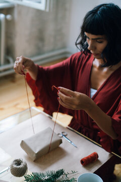 Woman wrapping Christmas gifts indoor