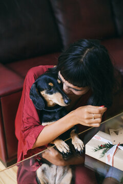 Woman spending time with her small black dog indoor