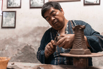 Mexican artisan sculpting with mud