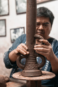 Mexican artisan sculpting with mud
