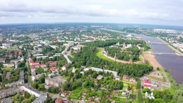 Panoramic aerial view of the Volkhov River and the old town of Veliky Novgorod, the red brick Kremlin in the rays of the setting sun and natural attractions of Russia.