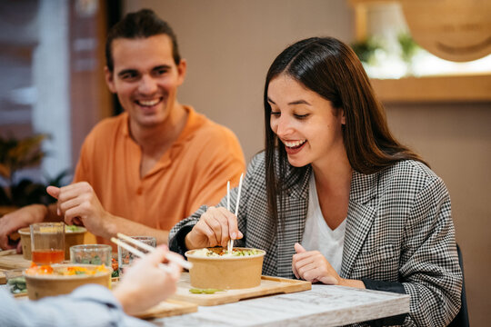 Couple eating poke bowl with chopsticks