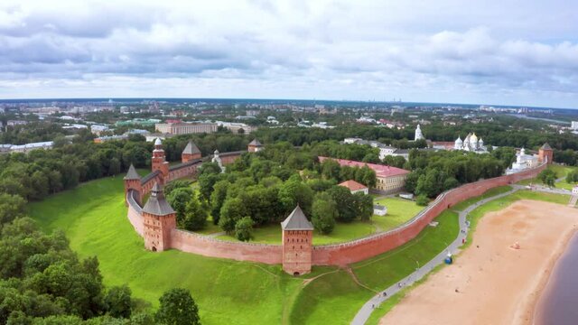 Panoramic aerial view of the Volkhov River and the old town of Veliky Novgorod, the red brick Kremlin in the rays of the setting sun and natural attractions of Russia.
