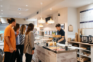 Group of friends ordering at the counter in a poke restaurant