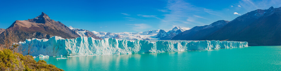 Panoramic view over gigantic Perito Moreno glacier in Patagonia with blue sky and turquoise water...