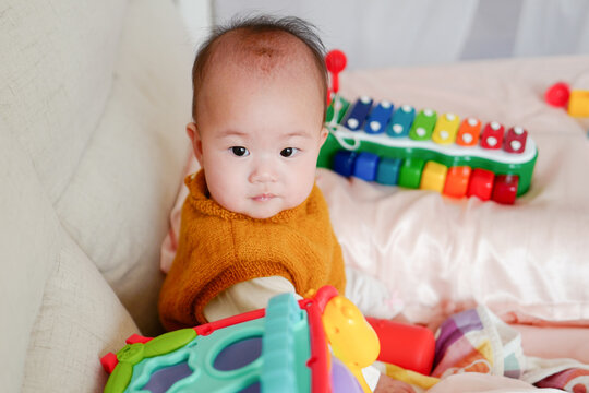 portrait of cute baby girl lying on bed at home