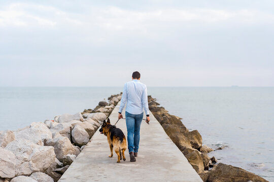 Man walking outdoor with his cute german shepherd dog