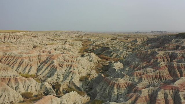 Colorful rock formations of the Badlands in South Dakota. Aerial 4K drone shot flying fast and rising up.
