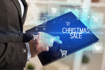 Fototapeta na wymiar Young person makes a purchase through online shopping application with CHRISTMAS SALE inscription