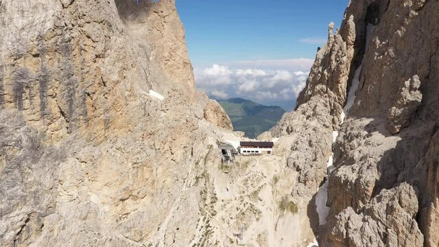 Drone flight around cable car and restaurant on the impressive Sassolungo mountain in the Dolomites, tourism and travel in Italy Europe
