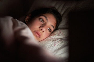 Girl watching movie in bed