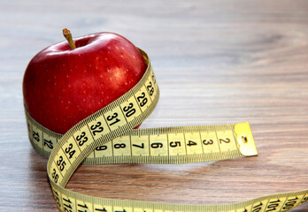 A red Apple is measured by a meter. Slimness and diet.