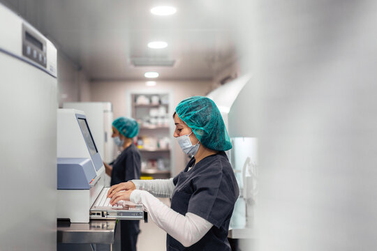 Biologists working on microscope in IVF laboratory