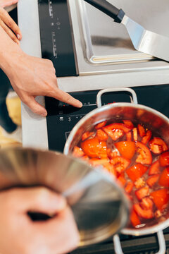 Crop man turning on stove under saucepan