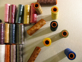 A set of multi-colored thick yellow, brown, black, blue, pink, red., green threads for sewing...