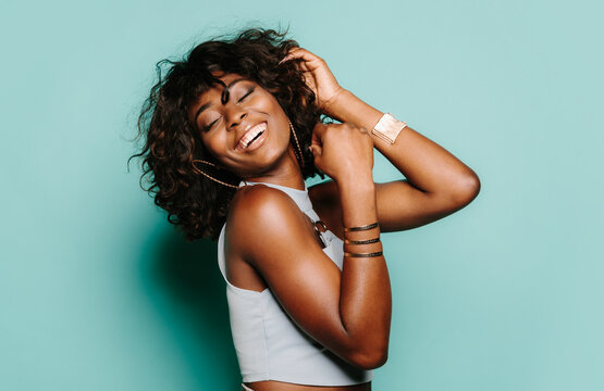 Happy young black woman posing over blue background