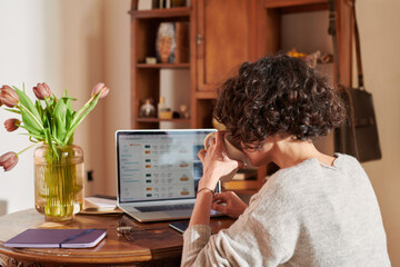 Woman working on laptop and drinking coffee.