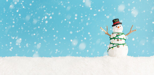 Happy snowman standing in winter christmas landscape