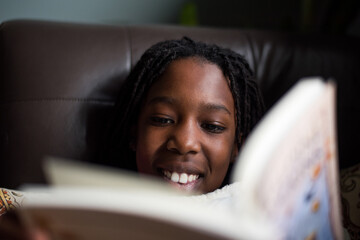 Smiling black girl reading a book