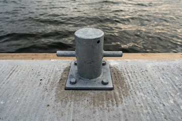 Steel bollard attached to pier with solid screws