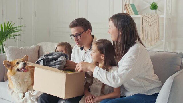 The Family Satisfied By a Quick Delivery. Unpacking of Order From Online Shops. Happy Family Opens Received Parcel in a Big Carton Box. Family`s Joint Purchases.