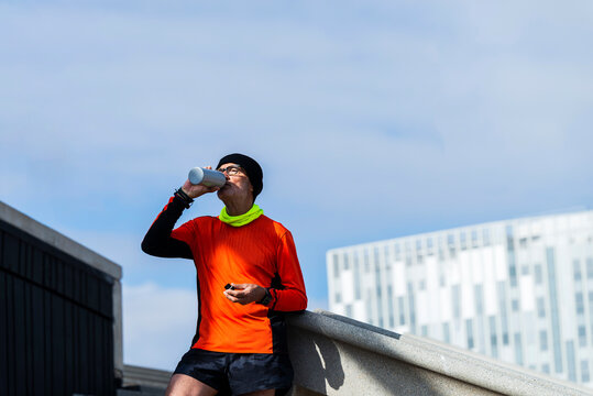 Senior sportsman drinking water during workout