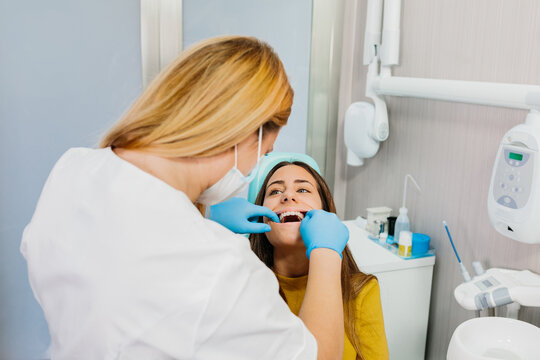 Dentist examining teeth of female at workplace