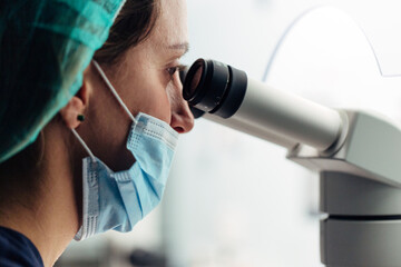 Biologist working on microscope in IVF laboratory