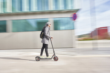 Confident male riding electric transport in city