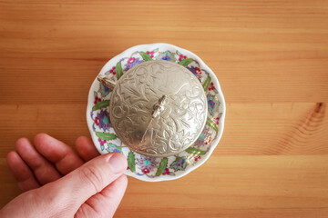 Top view of Turkish tea in traditional glass on wooden table. Man hand holding tea plate.