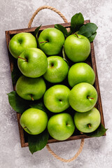 Ripe green apples in wooden box.