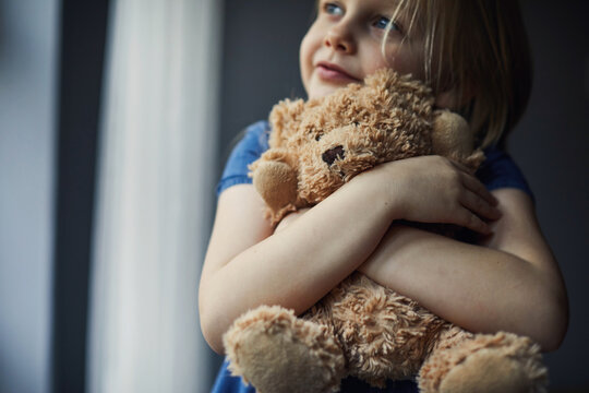 Naklejki Child holding a teddy bear