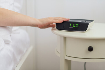 Alarm clock waking up an anonymous woman