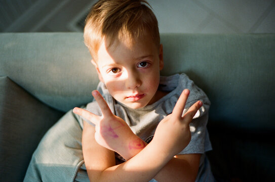 Cute young boy looking cool and flashing a defiance sign with his fingers