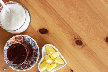 Top view of traditional Turkish tea, sugar and lemon on wooden table  with copy space.
