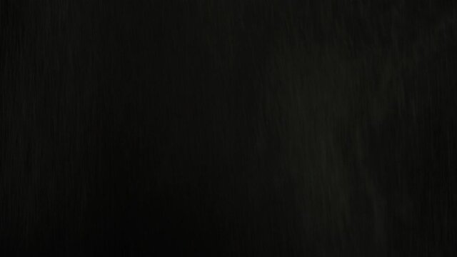 Rain drops falling on black background sfx. Real water rain motion blur at night. Tropical rainforest foggy thunderstorm shower and high humidity. Special effects of the shower or rainfall.
