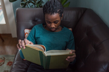 Black girl reading on a couch