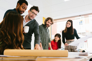 Stylish and creative colleagues at desk in office