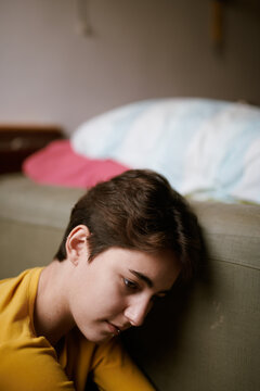 Depressed girl sitting on floor at home