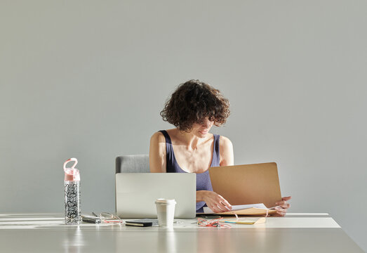 Young woman opening folder in office